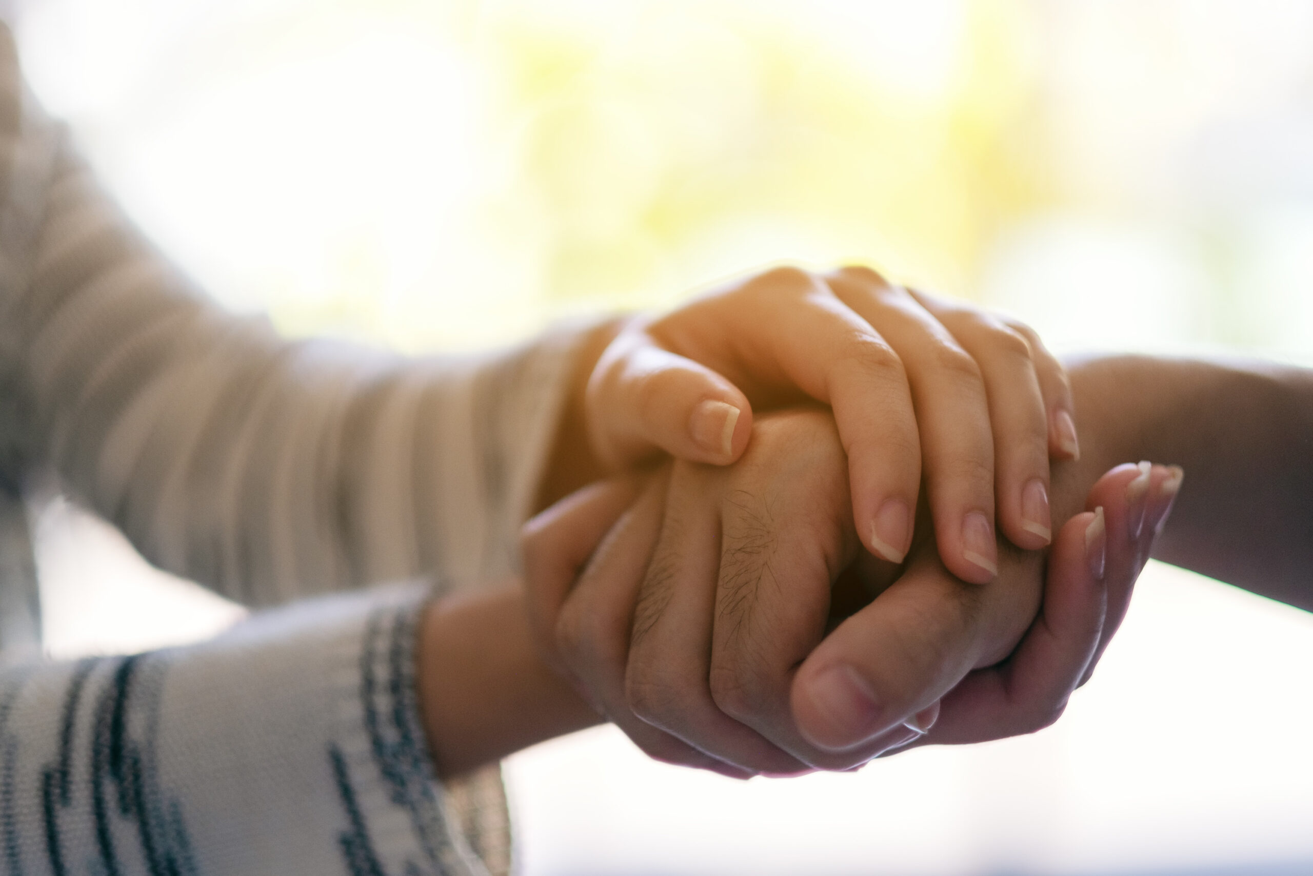 A man and a woman holding each other hands for comfort and sympa South Downs Natural Burial Ground